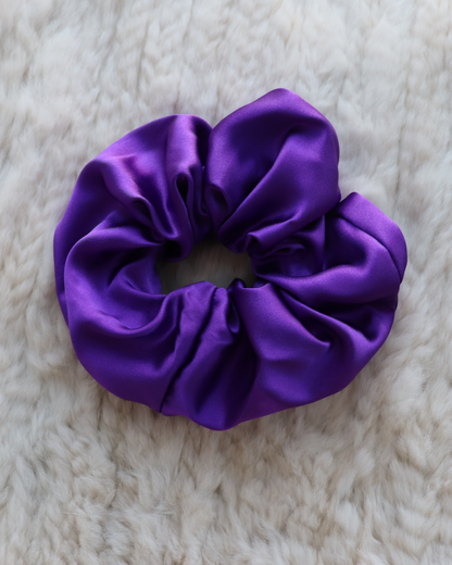 Single top-down view of a Royal Purple mulberry silk scrunchie, highlighting its smooth, luxurious folds and vibrant deep color. Perfect for all hair types.