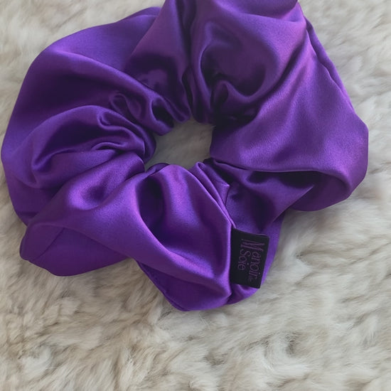 Video demonstrating the Royal Purple mulberry silk scrunchie as it is flipped to show both sides, highlighting its smooth texture, elegant drape, and consistent luxurious appearance from all angles.