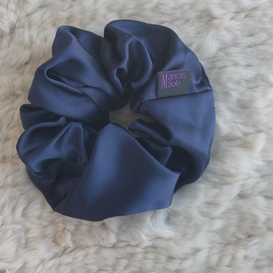 Video demonstrating the Midnight Navy mulberry silk scrunchie as it is flipped to show both sides, highlighting its smooth texture, elegant drape, and consistent luxurious appearance from all angles.